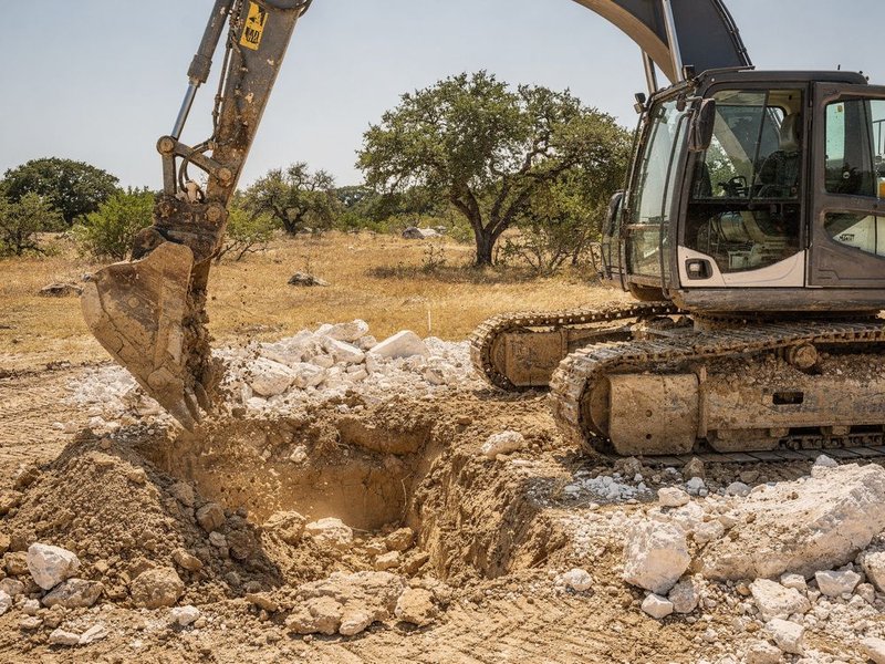 Excavator digging a foundation and grading a lot in Fort Worth, TX